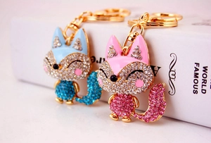 Close-up of pink and blue rhinestone fox keychains with gold-plated alloy details