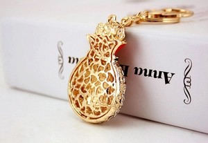 Macro view of pomegranate keychain with gold plating and sparkling crystals