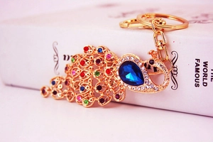 Macro shot of colorful rhinestones on a gold-plated peacock keychain accessory