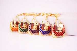 Detail of colorful handbag keychains with crystals and gold finish in five vibrant colors