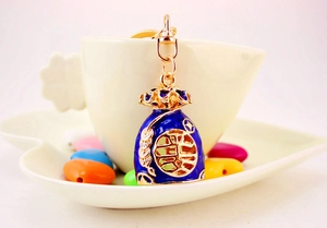 Macro shot of a blue enamel Chinese fortune bag keychain with gold Fu character detail