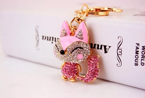 Close-up of cute pink crystal fox keychain with golden plating and sparkling rhinestones