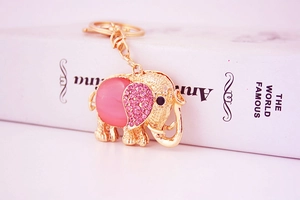 Detailed close-up of golden elephant keychain with pink rhinestones and cat eye stone inlay