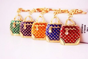 Detailed macro of rhinestone heart handbags keychains in five vibrant enamel colors