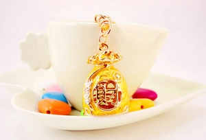 Close-up of golden money bag keychain with hollowed wealth character and white rhinestones