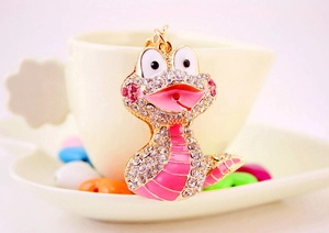 Détail macro d'un porte-clés serpent de dessin animé doré serti de strass roses