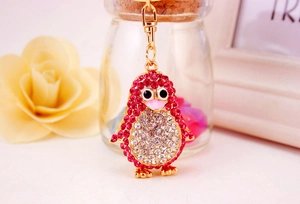 Close-up of a golden penguin keychain with sparkling pink and white rhinestones