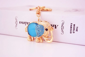Close-up of golden elephant keychain with blue gemstone and sparkling rhinestones