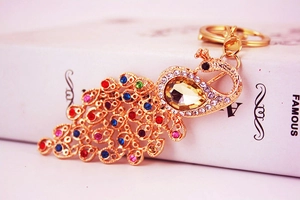 Macro shot of peacock keychain with vibrant colorful rhinestones on a golden metal base