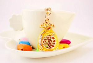 Detail view of a Chinese lucky bag keychain with yellow enamel and a crystal Fu character