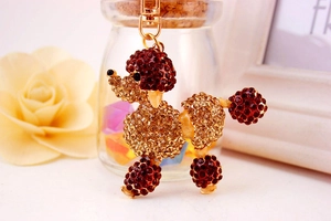 Detail of poodle keychain with brown crystals and gold lobster clasp for handbags