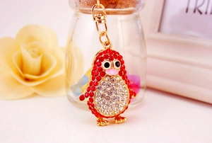 Close-up of a sparkling penguin keychain with red and white rhinestones and gold base