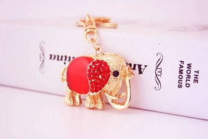 Macro shot of gold-plated elephant keychain with red rhinestones and gemstone detailing