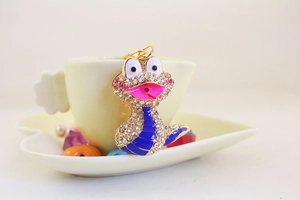 Détails d'un porte-clés serpent de dessin animé avec strass et finition en émail bleu