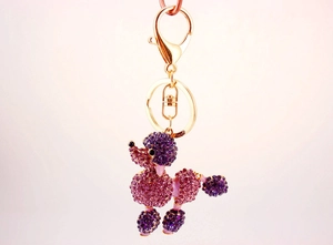 Detailed macro view of purple and pink gradient crystal poodle keychain with lobster clasp