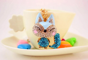 Close-up of cute cartoon fox keychain with blue rhinestones and gold alloy plating