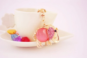 Detailed macro view of a golden elephant keychain with pink rhinestones and a gemstone body