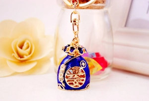 Macro shot of dark blue enamel lucky bag keychain with gold plating and Fu character