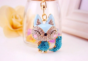 Detail of cute blue fox keychain with sparkling crystals and gold enamel finish