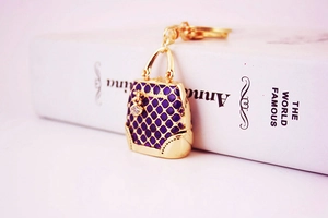 Detailed view of a purple enamel handbag keychain with sparkling rhinestones and gold alloy