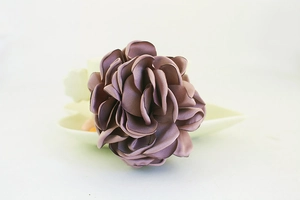 Gros plan d'un porte-clés rose en tissu fait main avec des pétales de couleur prune