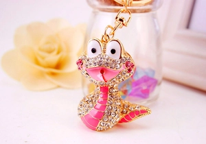 Détails porte-clés serpent doré avec strass roses et finitions en émail coloré