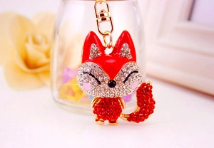 Close-up of golden fox keychain with red rhinestones and delicate enamel details