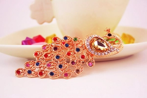 Detailed close-up of colorful crystal peacock keychain with champagne water-drop stone