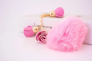 Detail of pink plush heart keychain with gold chain and delicate leather rose charms