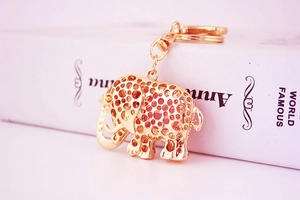 Close-up of a golden hollow elephant keychain with intricate cutouts and sparkling crystal