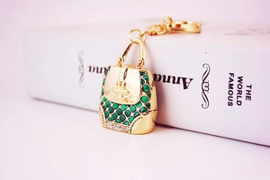 Detailed macro view of a green enamel handbag keychain with sparkling white rhinestones
