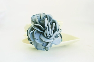 Vue détaillée d'une rose en satin bleu gris faite main avec des pétales de soie étagés