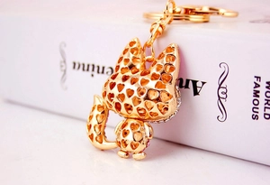 Detail of a golden fox keychain with heart-shaped cutouts and sparkling pink rhinestones