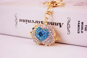 Macro view of the cute pig keychain featuring sparkling crystals and a blue heart detail
