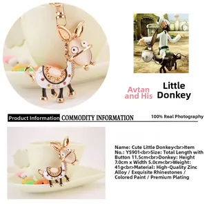 Detail of donkey keychain with white enamel, rhinestones and golden metal hardware