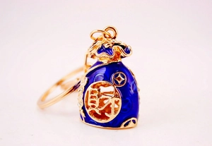 Detail of blue enamel lucky bag keychain with gold plating and rhinestones