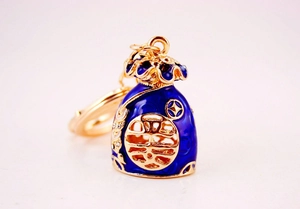 Close-up of golden lucky bag keychain with blue enamel inlay and Chinese character Fu