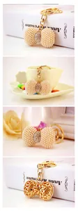 Detailed view of pearl bow keychain featuring gold metal base and sparkling crystal accents