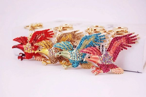 Détail de porte-clés aigle étincelants avec strass en rouge, or, bleu et rose fuchsia
