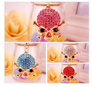 Dettaglio di portachiavi a forma di teschio con strass colorati in rosa, blu, bianco e rosso