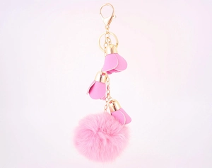 Detail of pink faux fur pompom keychain with leather flower petals and golden clasp