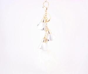 Detail of a gold lobster clasp with silver faux leather petals and white fur pompom