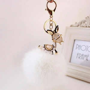 Detailed view of donkey keychain with white faux fur pompom and rhinestone crystals