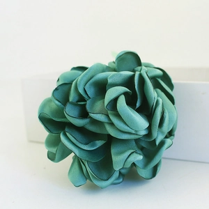 Porte-clés créatif fleur en tissu bleu avec bords brûlés sur une boîte cadeau