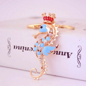 Porte-clés hippocampe doré avec émail bleu, strass brillants et petit charme de couronne