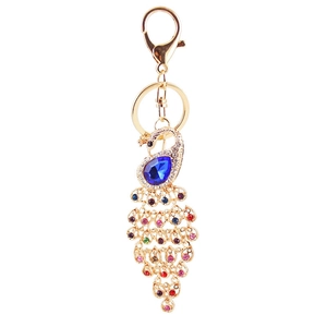 Colorful peacock keychain with blue gemstone and sparkling crystals on golden alloy base