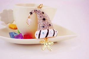 Gros plan d'un porte-clés chapeau de Noël étincelant avec strass et pendentif flocon doré