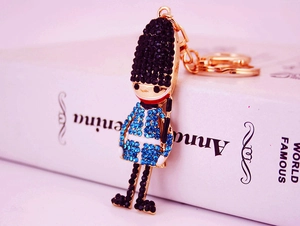 Close-up of royal guard crystal keychain with blue and black rhinestones on gold base