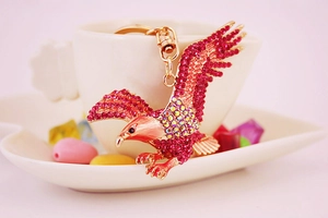 Close-up of eagle keychain featuring purple rhinestones and golden metal wings detail