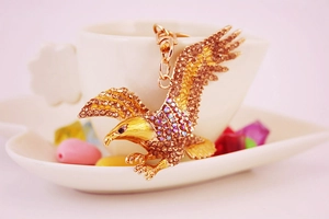 Detailed close-up of eagle keychain with sparkling rhinestones perched on a white cup